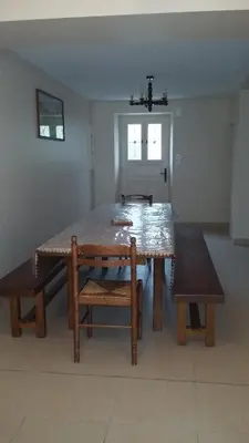 a dining room table and bench in a room at La Nappie in Réalmont