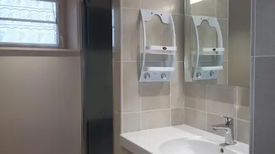 a bathroom with a sink and two mirrors on the wall at La Nappie in Réalmont