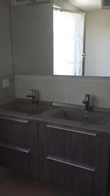 a bathroom with two sinks and a large mirror at La Nappie in Réalmont