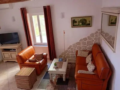 a living room with two leather chairs and a table at La Maison des Vendangeurs à Puisserguier in Puisserguier