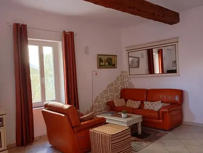 a living room with a couch and a chair at La Maison des Vendangeurs à Puisserguier in Puisserguier