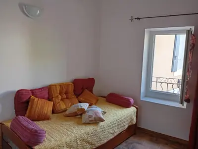a room with a couch with pillows and a window at La Maison des Vendangeurs à Puisserguier in Puisserguier