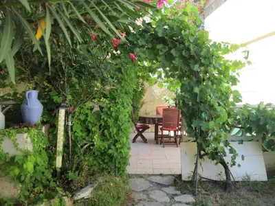 a garden with an arch covered in green plants at La Maison des Vendangeurs à Puisserguier in Puisserguier