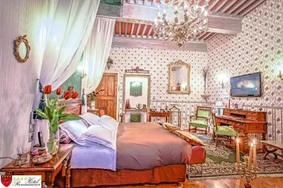 a bedroom with a large bed and a piano at Hôtel Renaissance in Castres