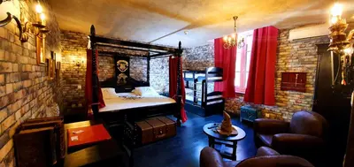 a small room with a bed and a brick wall at Hôtel Renaissance in Castres