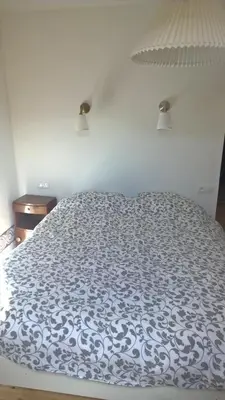 a bed with a blue and white comforter on it at Cafe Vals in Vals