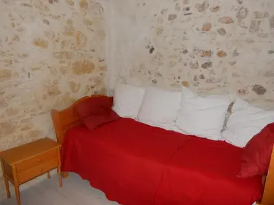 a bed with a red blanket and white pillows at Cafe Vals in Vals