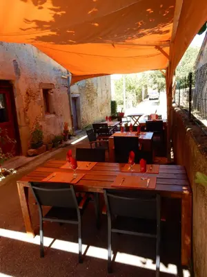 a wooden table and chairs under an orange tent at Cafe Vals in Vals