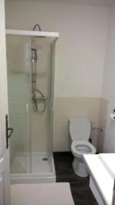 a bathroom with a toilet and a glass shower at Cafe Vals in Vals
