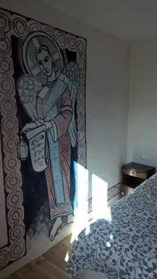 a painting of a woman on a wall next to a bed at Cafe Vals in Vals