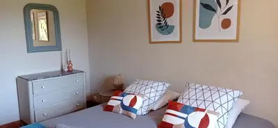 a bedroom with a bed and a dresser and a mirror at Gîte rural, relais équestre Le Tulipier in Pradelles-Cabardès