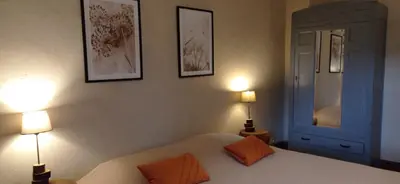 a bedroom with a bed with two lamps on it at Gîte rural, relais équestre Le Tulipier in Pradelles-Cabardès