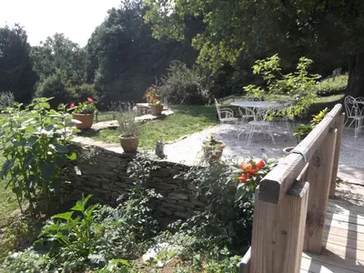 a garden with a fence and a table and chairs at Gîte rural, relais équestre Le Tulipier in Pradelles-Cabardès