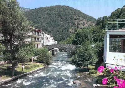 a bridge over a river in a town at Hotel Axat in Axat