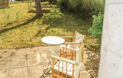 a table and two chairs sitting next to a table at Amazing Home In Ribaute in Ribaute