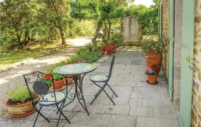 a patio with a table and chairs and potted plants at Amazing Home In Ribaute in Ribaute