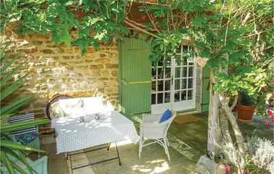 a patio with a table and chairs in front of a building at Amazing Home In Ribaute in Ribaute