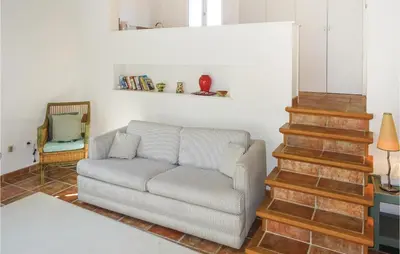 a living room with a couch and a staircase at Amazing Home In Ribaute in Ribaute