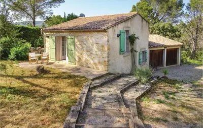 a small stone cottage with a table and chairs in a yard at Amazing Home In Ribaute in Ribaute