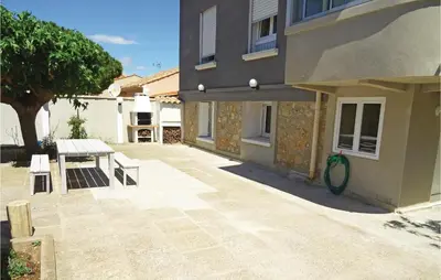 a patio with a bench and a table next to a building at Cozy Apartment In Vinassan With Wifi in Vinassan