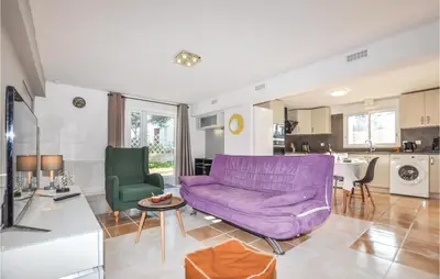 a living room with a purple couch and a kitchen at Cozy Apartment In Vinassan With Wifi in Vinassan