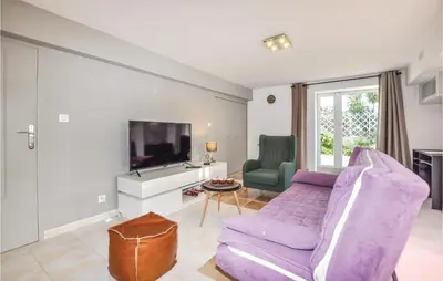 a living room with a purple couch and a tv at Cozy Apartment In Vinassan With Wifi in Vinassan