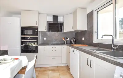 a kitchen with white cabinets and a sink at Cozy Apartment In Vinassan With Wifi in Vinassan