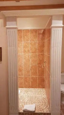 a bathroom with a shower with orange tile at La Lucques Masabelle in Mirepeisset