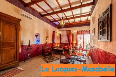 a living room with a large room with red walls at La Lucques Masabelle in Mirepeisset
