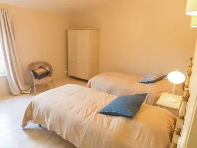 a bedroom with two beds and a chair at Holiday Home in Loupia with Private Pool in Loupia