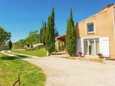 a house with trees next to a gravel driveway at Holiday Home in Loupia with Private Pool in Loupia