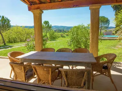 a wooden table and chairs on a porch at Holiday Home in Loupia with Private Pool in Loupia