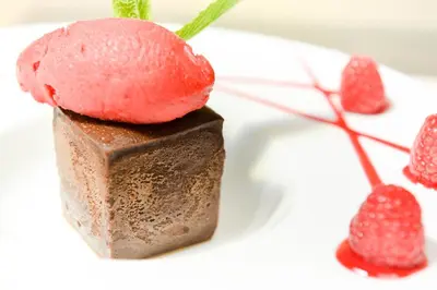 a chocolate dessert with strawberries on a white plate at Logis Hôtel Restaurant des Corbières in Lagrasse