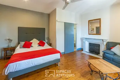 a bedroom with a bed and a couch and a fireplace at Logis Hôtel Restaurant des Corbières in Lagrasse