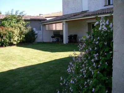 a house with a yard with purple flowers at gite a la campagne in Noailhac
