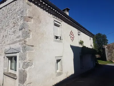 a white building with a cross on the side of it at gite a la campagne in Noailhac
