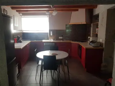 a kitchen with red cabinets and a table and chairs at gite a la campagne in Noailhac