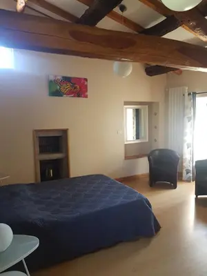 a bedroom with a bed and chairs in a room at gite a la campagne in Noailhac