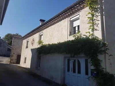 a white brick building with a white garage at gite a la campagne in Noailhac