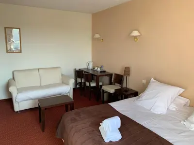 a hotel room with a bed and a chair and a table at Le Mas De Gaujac in Lézignan-Corbières