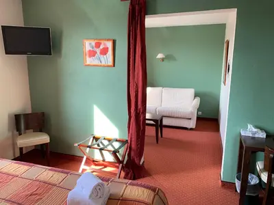 a room with a bedroom with a bed and a chair at Le Mas De Gaujac in Lézignan-Corbières