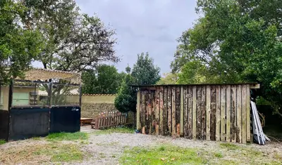 a wooden fence and a gate in a yard at La Bonne Planque - Maison éclusière de La Planque in Mas-Saintes-Puelles