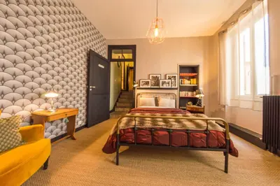 a bedroom with a bed in the middle of a room at RétroMirabeau - CHAMBRE Suite & APPARTEMENTS de Charme - Localisation Prémium in Narbonne
