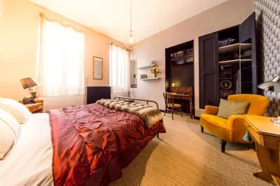 a bedroom with a bed and a chair and a desk at RétroMirabeau - CHAMBRE Suite & APPARTEMENTS de Charme - Localisation Prémium in Narbonne
