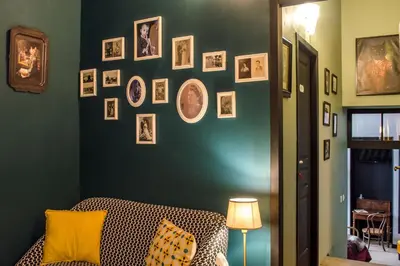 a room with a green wall with pictures on it at RétroMirabeau - CHAMBRE Suite & APPARTEMENTS de Charme - Localisation Prémium in Narbonne