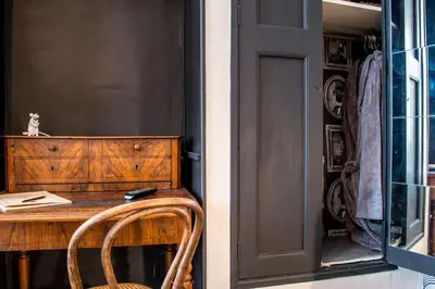 a room with a wooden table with a chair next to a door at RétroMirabeau - CHAMBRE Suite & APPARTEMENTS de Charme - Localisation Prémium in Narbonne