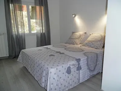 a bedroom with a bed with a white comforter at Peaceful Poolside Escape in Montouliers