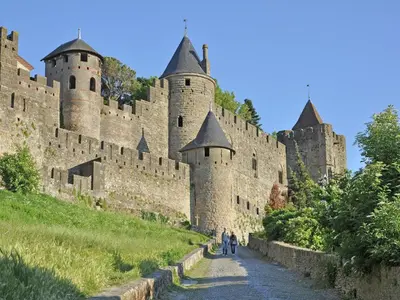 a large castle with people walking down a road at Peaceful Poolside Escape in Montouliers