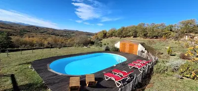 a swimming pool with chairs and a wooden deck at Fount de Cousteno in Limbrassac