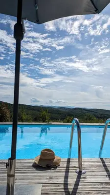a hat sitting on a deck next to a swimming pool at Fount de Cousteno in Limbrassac